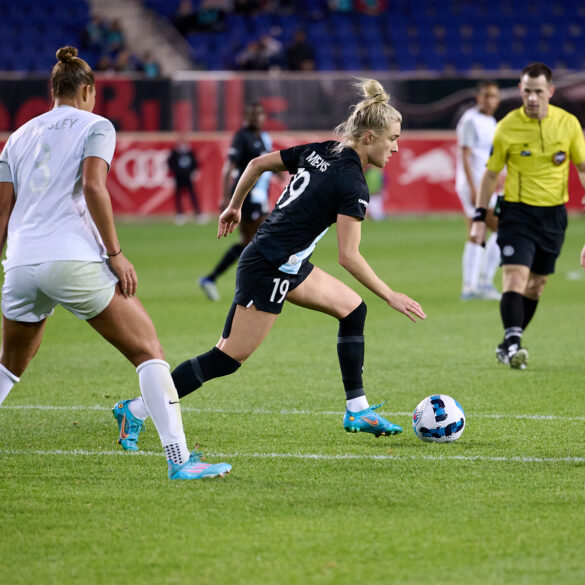 Kristie Mewis dribbles against three Orlando Pride players