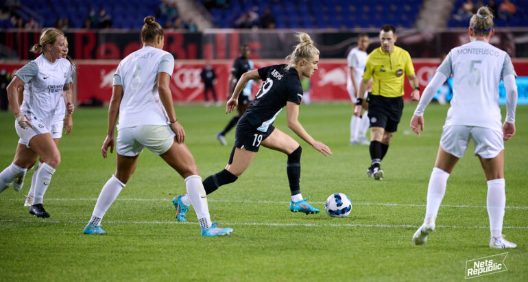 Kristie Mewis dribbles against three Orlando Pride players